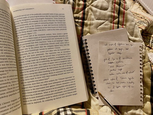 A book opened to a page halfway through (left) and some scraps of paper with scratchy handwriting (right).