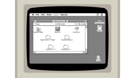A black-and-white screenshot of an old Mac operating system, within an outline of a beige Macintosh computer. The screenshot shows a file browser, with a file with a newspaper icon and the name 'Read Me'.