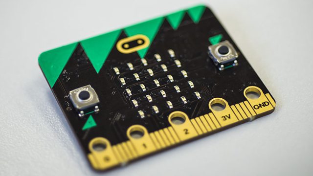 A small black circuit board with a yellow and green stripe.