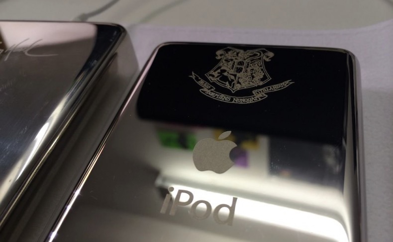 The silver back of an iPod, with a Hogwarts crest engraved near the top.