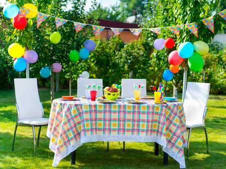 A photo of a table in a garden laid out for a party.