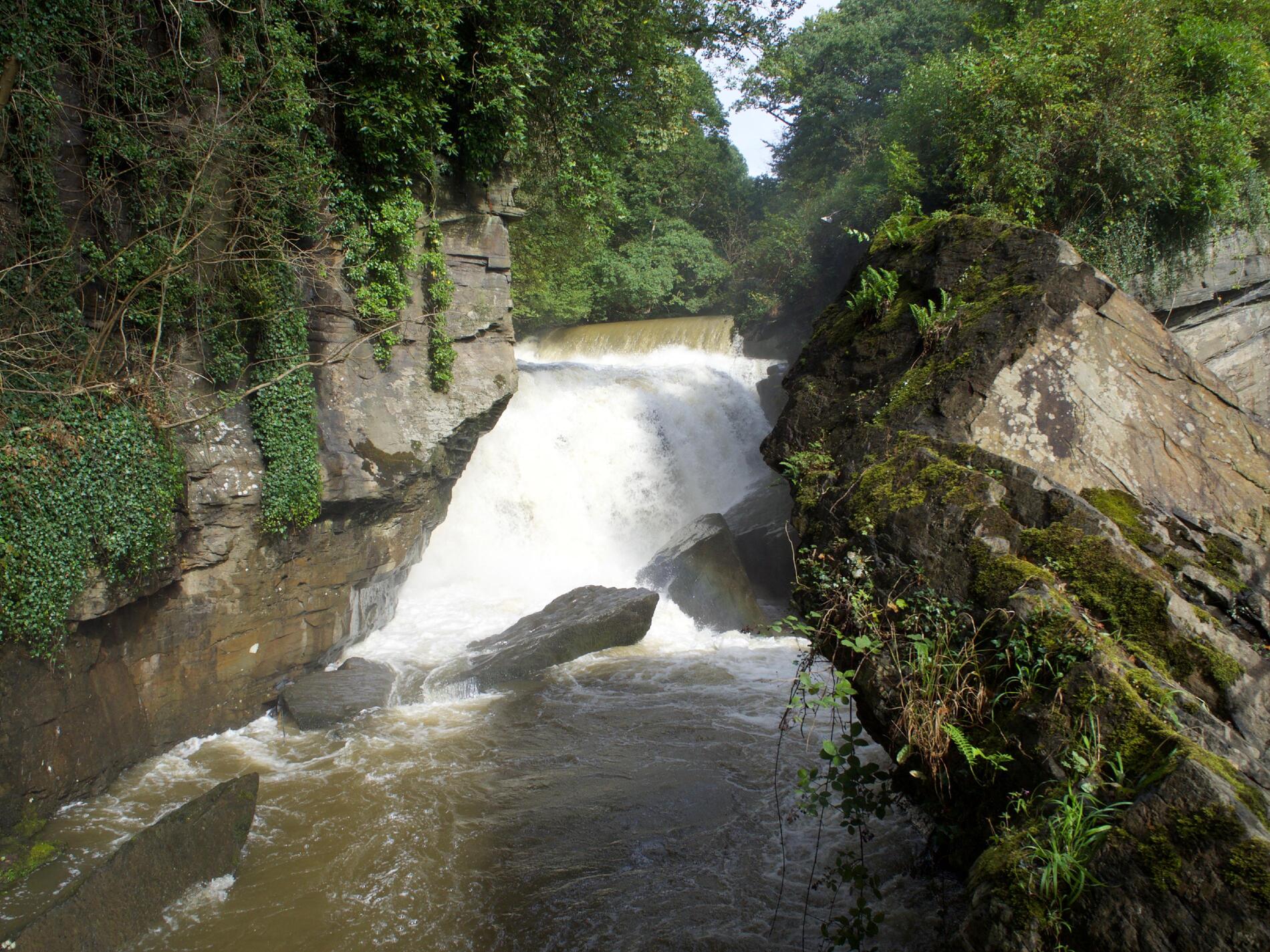 A waterfall visible between rocks.
