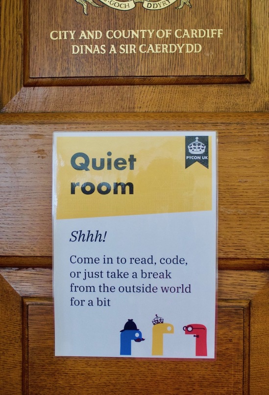 A sign on a brown wood-panelled door, with a yellow stripe at the top labelled “Quiet room”.