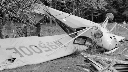 A black and white photo of a crashed plane, upside down.