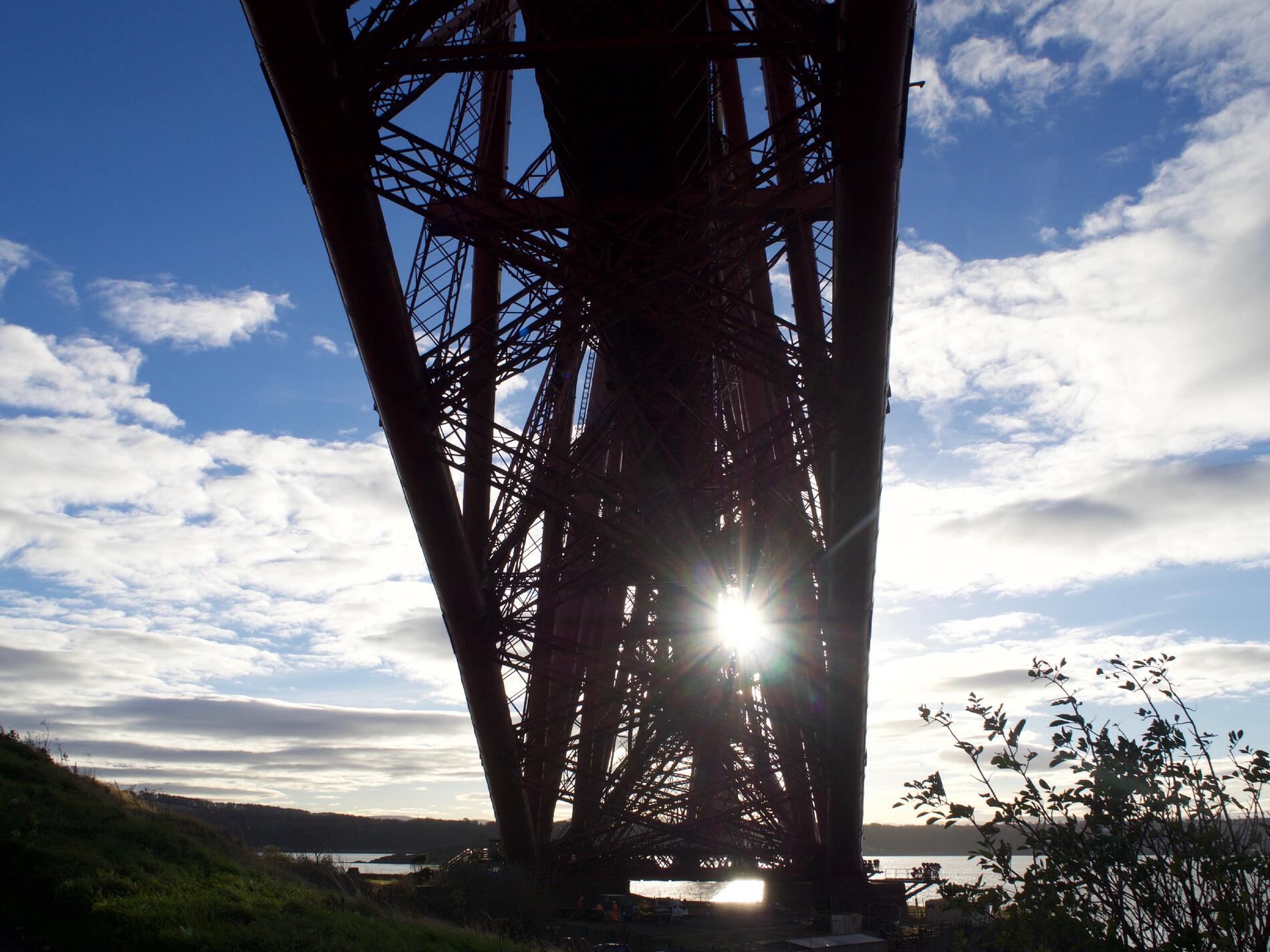 A silhouette of the girders in the bridge, looking up from underneath.