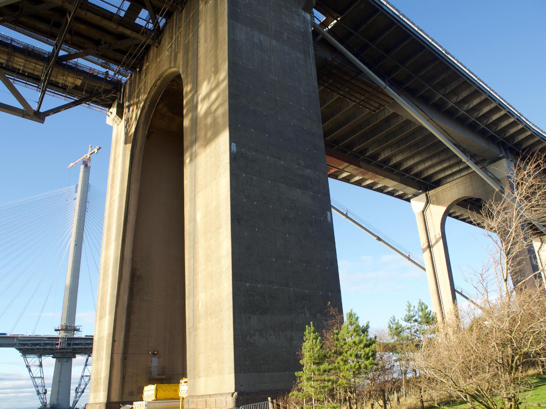 A single concrete support, with the ridged underside of the bridge visible.