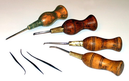 A collection of tools with wooden handles and sharp, pointed metal ends.
