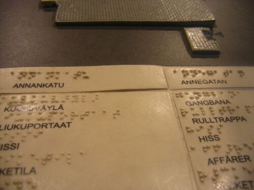 A page printed with Finnish words and embossed with braille.