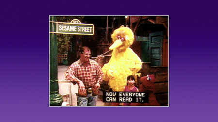 A screenshot from Sesame Street, with four characters on screen and a caption “Now everyone can read it”.