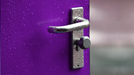 A purple door with a silver handle.