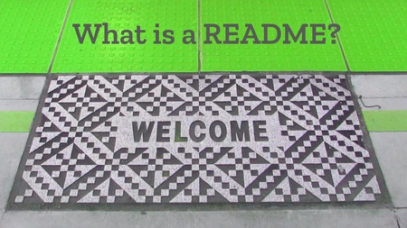 A station platform with a green cobbled edge and a black-and-white welcome mat. The welcome mat has a pattern of interspersed diamonds in different colours, and the word 'Welcome' in dark text at the centre. The green cobbled edge runs across the top of the image, and has the text 'What is a README?' overlaid in green.