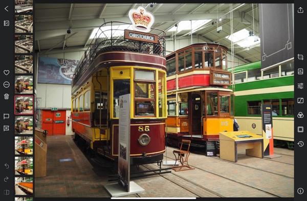 Screenshot of the Darkroom photos app. The photo of the two trams takes up most of the screen, with toolbars along the left and right, and a carousel of square thumbnails up the left hand side. The selected thumbnail is shown with a red outline, and the thumbnails are bigger and wider-spaced than in the built-in app.