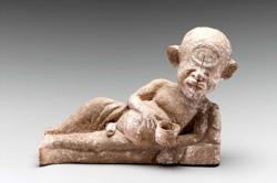 A small terracotta figure of a person reclining, holding a bowl. The figure's head is dominated by one large eye.