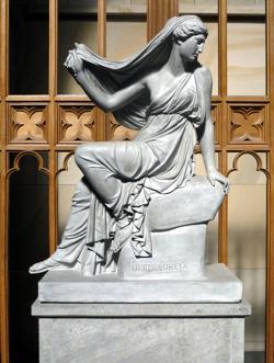 A statue of a woman perched on a plinth, looking over her shoulder. There's an inscription 'Persephone' at the base of the plinth.