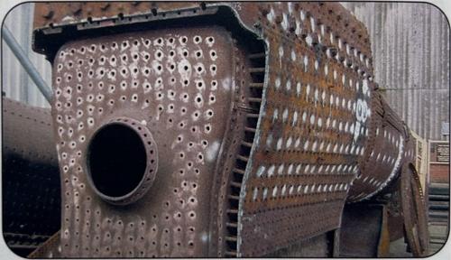 A large metal boiler made of an inner chamber and an outer skin, with thin rods visible connecting the two.