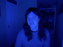 A photo of me in a blue room. Everything is dark and moody, like in a sci-fi film.