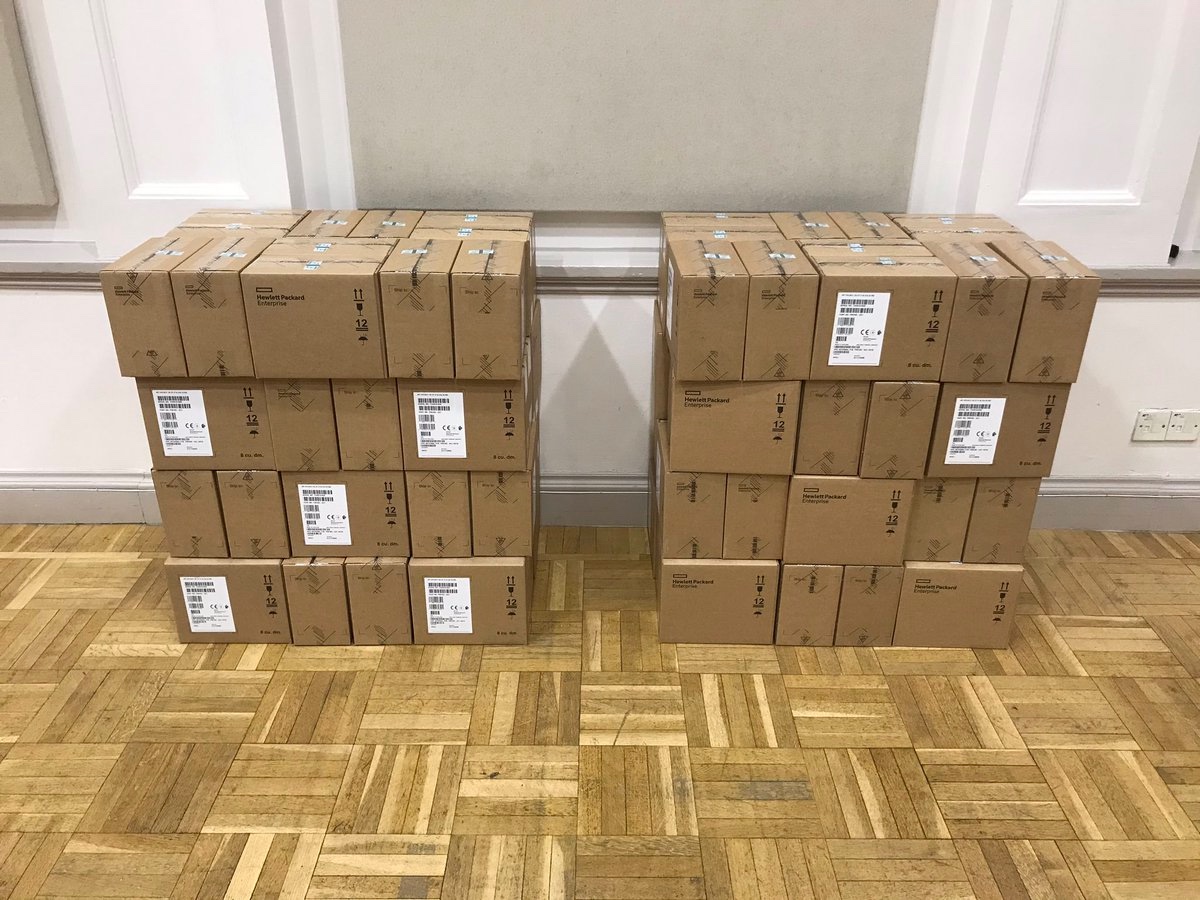 A photo of two large stacks of cardboard boxes. Each stack is about five boxes across, two boxes deep, four boxes high. Lots of boxes!